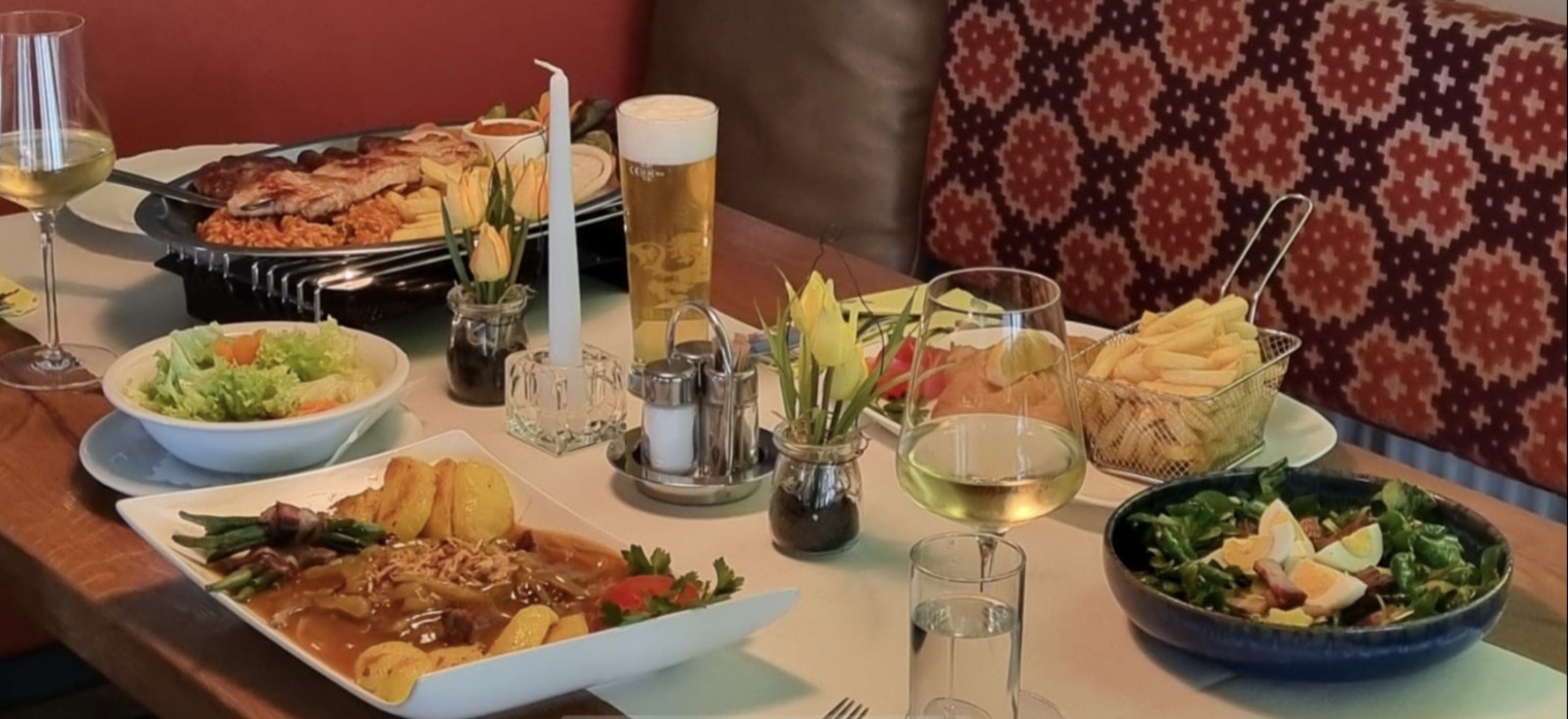 Gedeckter Tisch im Gasthof NIKI mit Grillplatte, Schnitzel und Salat